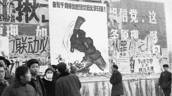 1967年2月,在“无产阶级文化大革命”期间,一小批中国青年走过几条革命性的大字报。自1966年5月文化大革命在北京大学发起以来,毛泽东的目标是在“大跃进”失败后重新夺回政权。(图片来源:JEAN VINCENT/AFP via Getty Images)