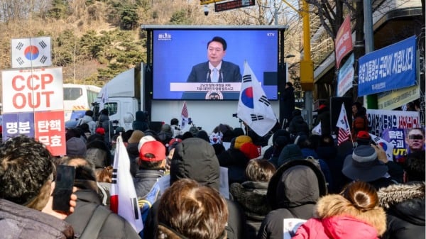 2025年2月20日,支持者在首尔中央地方法院附近的萤幕上观看韩国领导人尹锡悦(中)演讲的存盘片段,这位被罢免的韩国领导人成为该国第一位因实施戒严而接受刑事审判的在任国家元首。