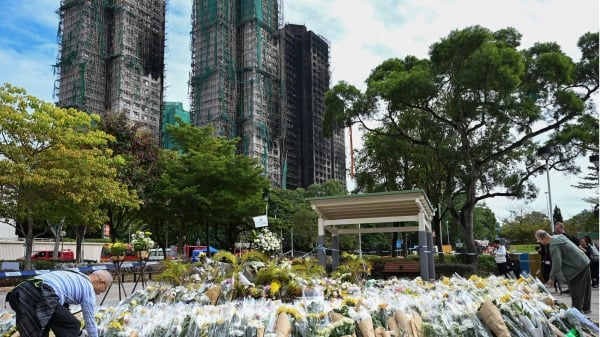 12月1日,在香港宏福苑公寓外的临时纪念碑前,许多市民献花悼念遇难者。