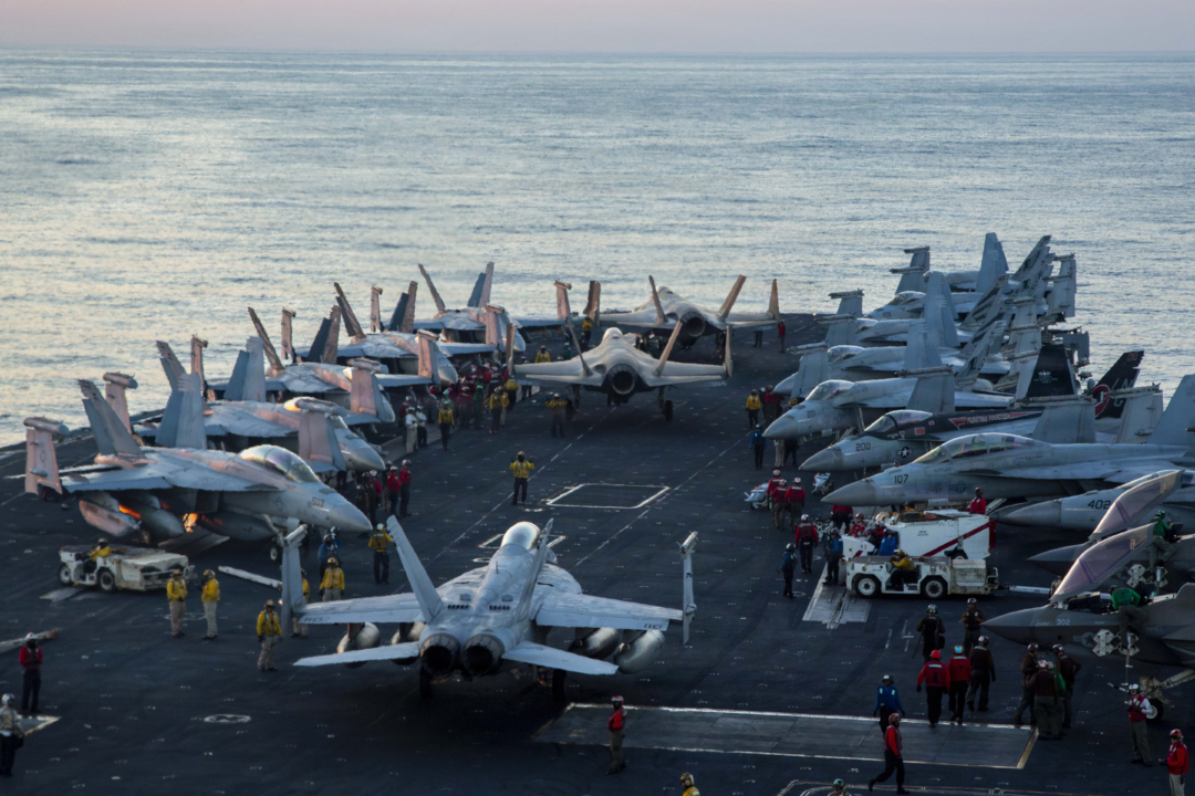 2026年2月28日,美军士兵在林肯号(CVN 72)航母的飞行甲板上,将战机引导至集结点,以支援“史诗之怒行动”(Operation Epic Fury)。(美国海军)
