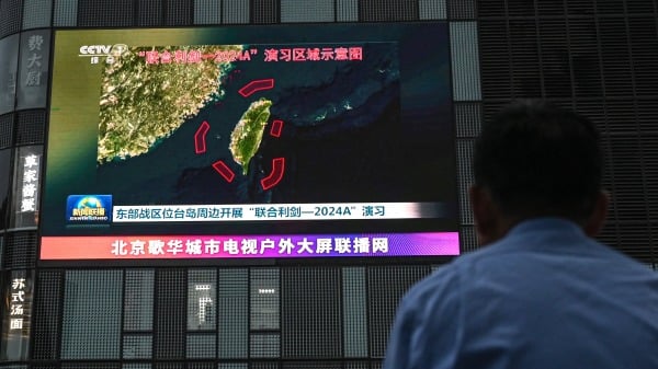 台海局势引发国际关注。图为户外萤幕播放着共军于2024年5月23日在台湾周边进行演习的新闻。(图片来源: JADE GAO/AFP via Getty Images))