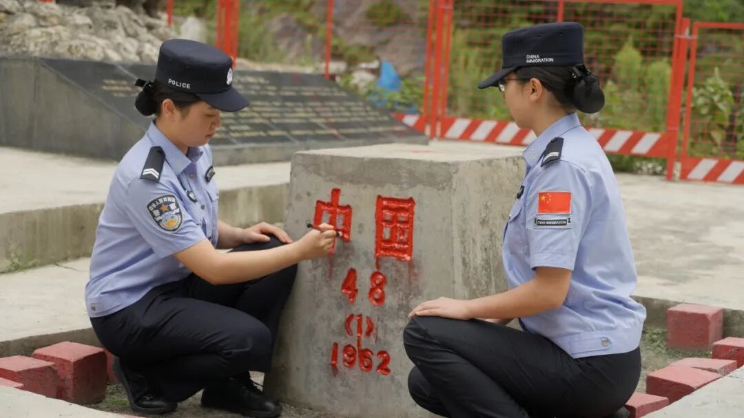 樊乐乐(左)和同事一起为界碑描红
